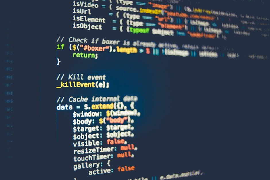 Close-up of a person's hands operating a laptop on a dark outdoor table, with the screen displaying lines of computer code in a text editor. The individual appears to be engaged in programming or web